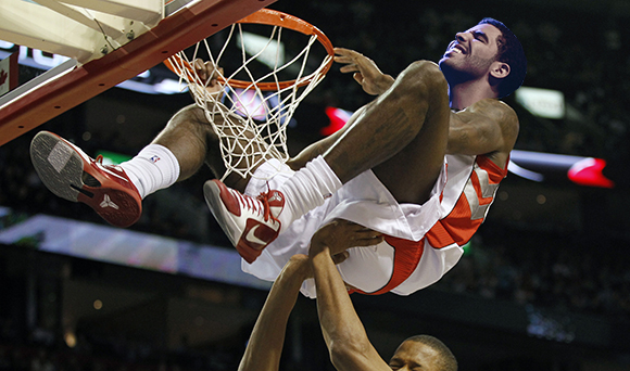 Raptors' Johnson celebrates his slam dunk over Knicks' Randolph during the first half of NBA pre-season action in Montreal