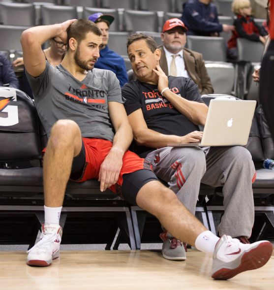 Toronto Raptors center Jonas Valanciunas (17) chats with assistant coach Bill Bayno before the NBA basketball game between the Toronto Raptors and the Philadelphia 76ers in Toronto on Wednesday, April 9, 2014. The Toronto Raptors players and staff are standing behind their starting centre after he was charged with drunk driving. (AP Photo/The Canadian Press, Peter Power)