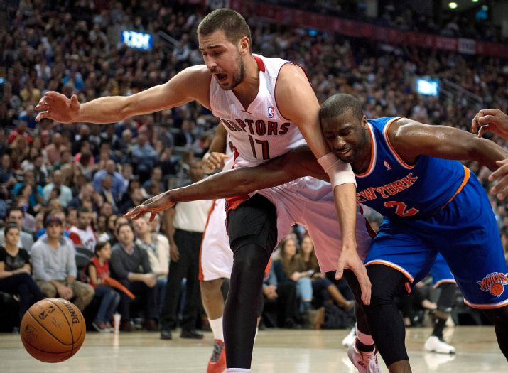 Toronto Raptors center Jonas Valanciunas (17) and New York Knicks guard Raymond Felton (2) chase down a loose ball during the first half of an NBA basketball game Friday, April 11, 2014, in Toronto. (AP Photo/The Canadian Press, Frank Gunn)