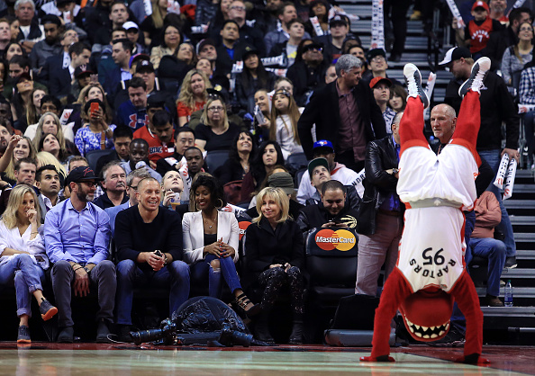 TORONTO, ON - APRIL 12: MMA fighter George St. Pierre (front row, 3rd L) laughs as The Toronto Raptors mascot, The Raptor, tries to impress him during a break in the second half of an NBA game between the Philadelphia 76ers and the Toronto Raptors at the Air Canada Centre on April 12, 2016 in Toronto, Ontario, Canada. NOTE TO USER: User expressly acknowledges and agrees that, by downloading and or using this photograph, User is consenting to the terms and conditions of the Getty Images License Agreement. (Photo by Vaughn Ridley/Getty Images)