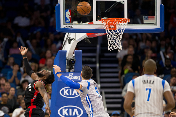 ORLANDO, FL - DECEMBER 18: DeMarre Carroll #5 of the Toronto Raptors goes to the basket against Nikola Vucevic #9 of the Orlando Magic at Amway Center on December 18, 2016 in Orlando, Florida. NOTE TO USER: User expressly acknowledges and agrees that, by downloading and or using this photograph, User is consenting to the terms and conditions of the Getty Images License Agreement. (Photo by Manuela Davies/Getty Images