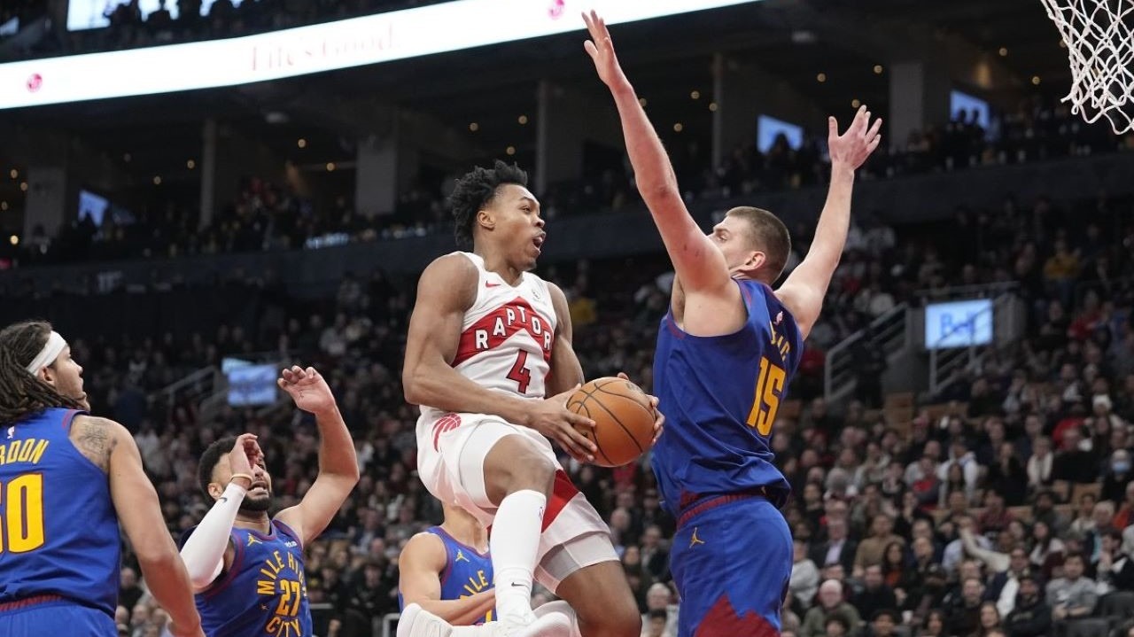Toronto Raptors forward Scottie Barnes (4) goes up to make a basket as Denver Nuggets center Nikola Jokic (15) defends during the second half at Scotiabank Arena