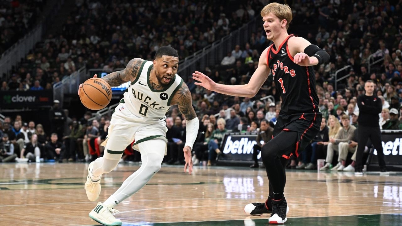 USA; Milwaukee Bucks guard Damian Lillard (0) drives to the basket against Toronto Raptors guard Gradey Dick (1) in the second half at Fiserv Forum.